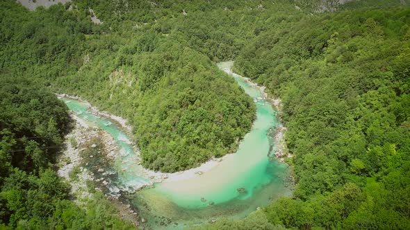 Aerial view of the calm water surrounded by nature at Soca river in Slovenia.
