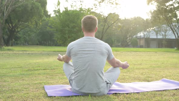 Rear View of Young Man Relaxing at the Park