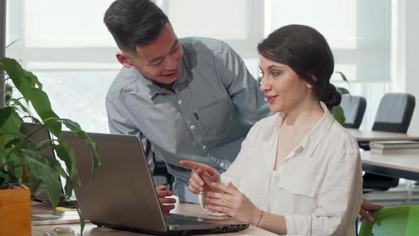 Asian Businessman Discussing Startup Ideas with His Female Colleague