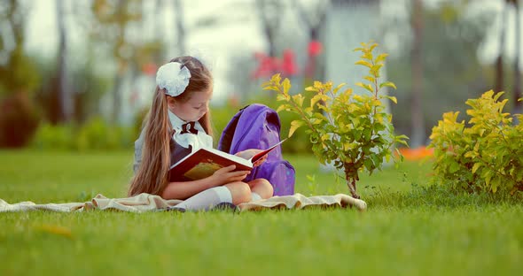 School Girl Reading Book on Lawn