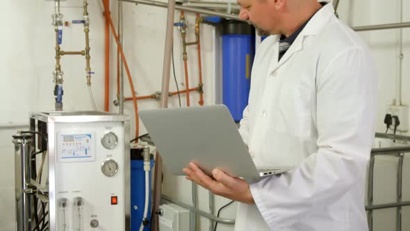 Male worker using laptop in factory