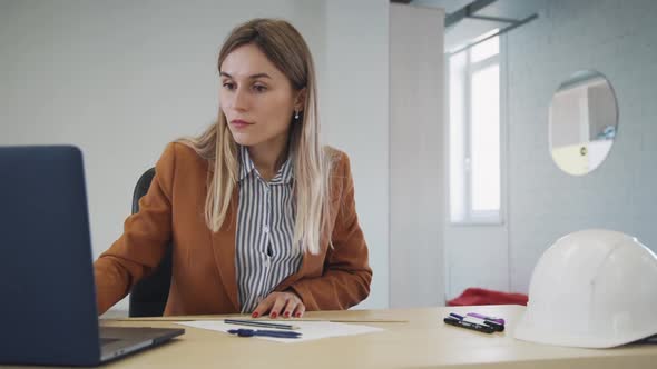 Woman Checking Information About Architect Project on Laptop and