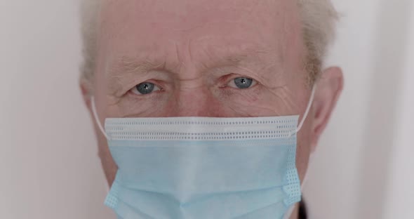 Sad Looking Into Camera and on Mask of Grandfather is Experiencing Quarantine