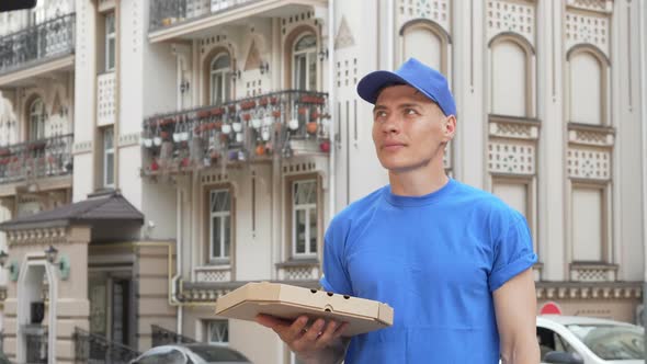 Cheerful Pizza Courier Smiling To the Camera After Looking Around on City Street