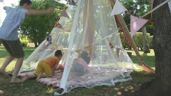 Children getting into a play tent in garden