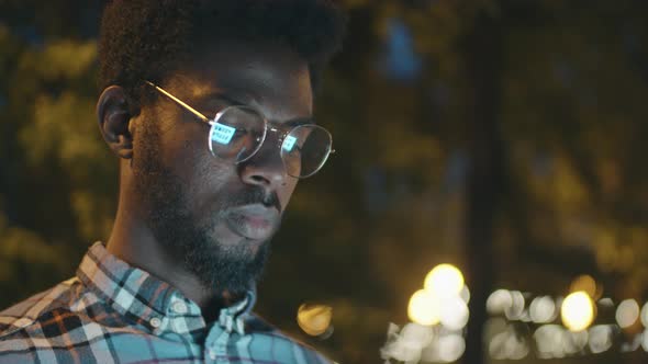 Afro-American Man Using Smartphone Outdoors in Evening