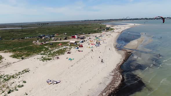 Landscape View on the Beach at the Seaside, Kite Surfers Are Gliding on Water 