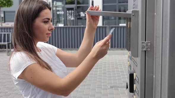 Woman Put Plactic Card for Paying Outdoors on Selfservice Car Wash