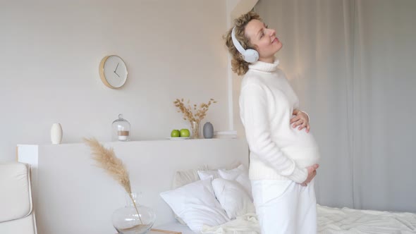 Young Smiling Pregnant Woman Dancing At Home. Happy Lifestyle And Pregnancy Concept.