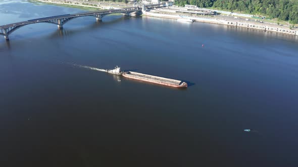 River Barge in Tow Floats Along the Channel of the River  Drone Aerial Orbit Shot