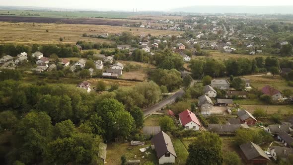 Aerial landscape of small town or village with rows of residential homes and green trees.