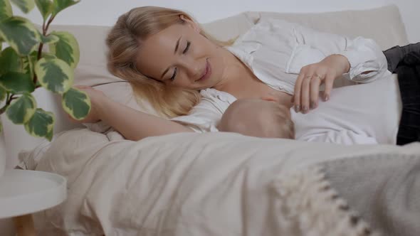 Young Smiling Mother Strokling Her Sleeping Son