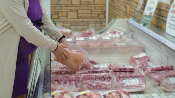 Pregnant Woman Buying Packed Pork Meat at Grocery