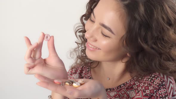 The girl holds sweet donuts in her hands, regretting that she can't eat them