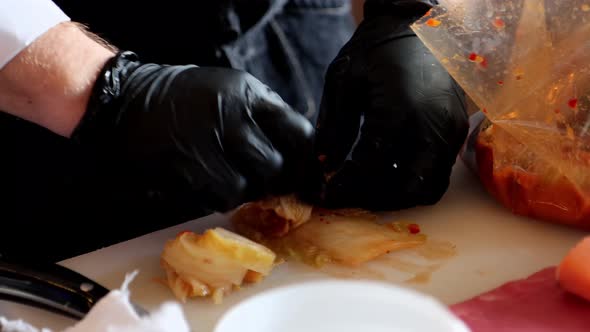 Closeup Hands in Gloves are Rolling Kimchi Korean National Dish