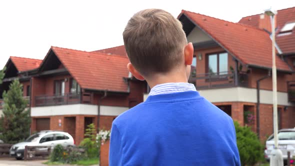 A Young Boy Looks Around a Suburban Neighborhood