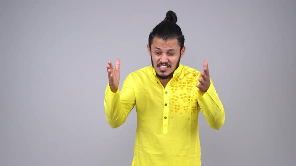 Unhappy Indian man shouting at someone in an Indian outfit