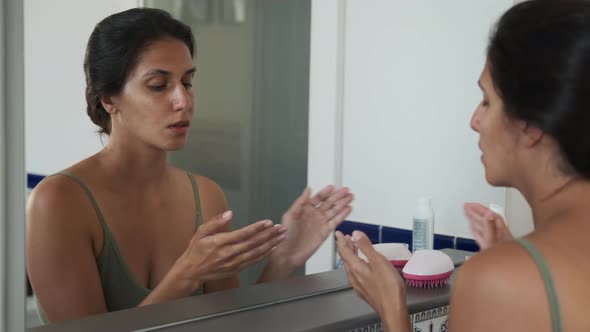 Woman Taking Care of Face Skin and Applying Cream