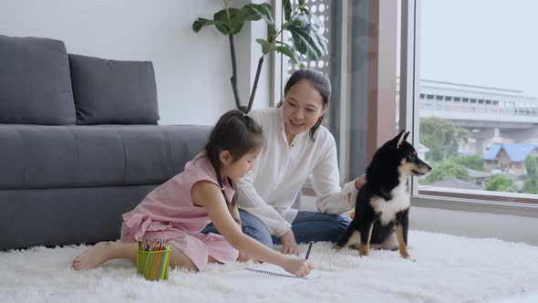 Single Asian mother taking care of daughter and dog at home