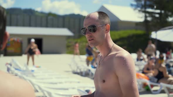 Closeup Travelling Dialog Bald Italian Man Stands on Beach Wearing Sunglasses Looks Like Mob