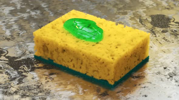 Squeezing green liquid dishsoap detergend on a yellow sponge. Kitchen cleaning
