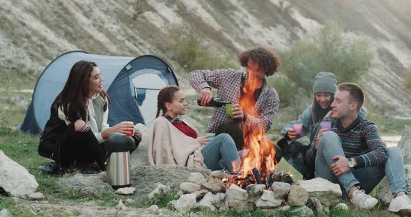 Five Friends at Camping Sitting in Front of Fire