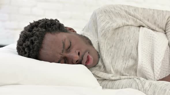 African Man Coughing in Bed