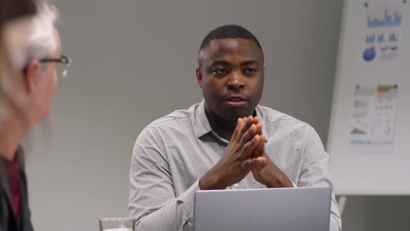 Afro-American Team Leader Talking to Colleagues at Business Meeting