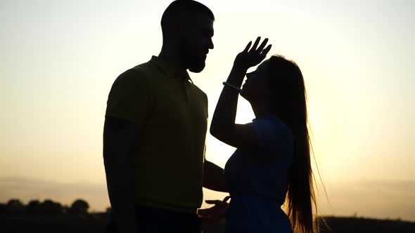 Close-up View of Silhouette of Young European Couple in Love Enjoying Romantic Evening in Field