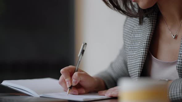 Business Woman Writing Something in Notebook