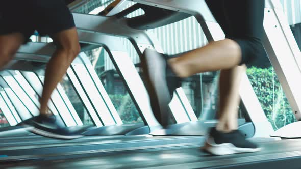 Close-up shot of people running on treadmill