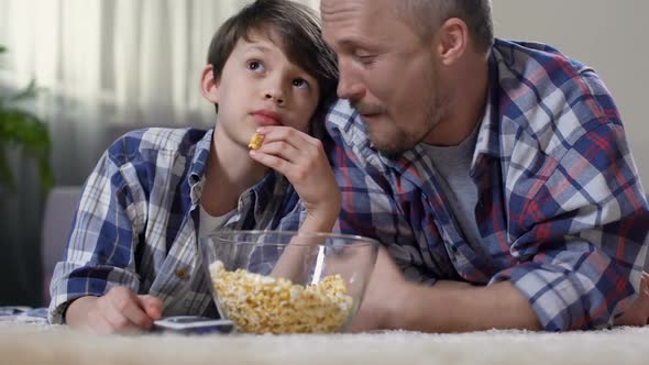 Father Hugging Little Son During Watching Film Home With Popcorn, Proud of Child