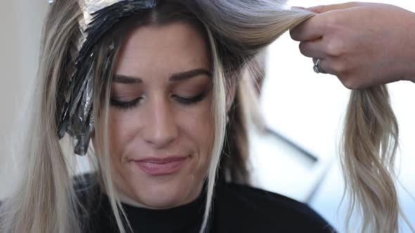 Young woman in salon having her roots bleached