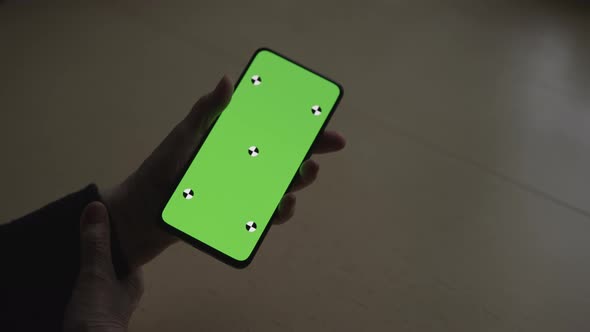 Handheld Shot of Old Female Hands Holding Smartphone with Green Screen Over Wood Vintage Table with