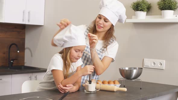 Young Blond Woman and Child Before Baking Cake