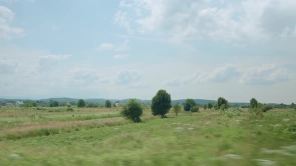 View From Window of Highspeed Train on Landscape of Beautiful Nature Wild Field and Forest on