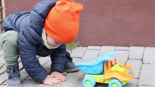 Little Boy Kid Plays with Toy Car Outside