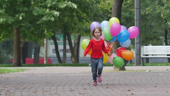 Emotional Girl Runs with Multicolored Balloons, Slow Motion