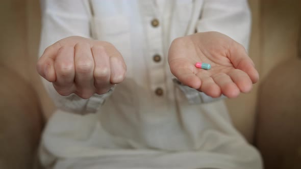 Female Choose Two Pills in Hands