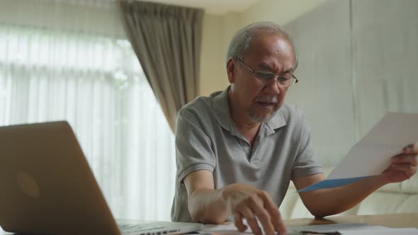 Asian depressed desperate senior elderly man feeling worried about money debt, financial problem.