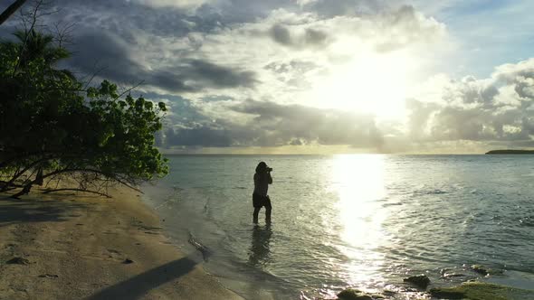 Single female tanning on marine tourist beach break by turquoise sea with clean sandy background of 