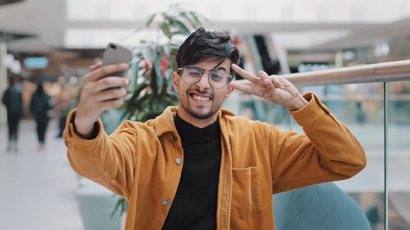 Young Handsome Arab Guy Blogger Model Holding Phone in Hand Photographed on Mobile Camera Posing