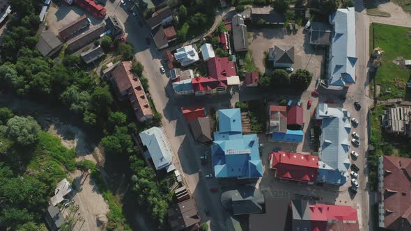 A Topdown Aerial View of the Roofs of Houses of a Small Town with a River Trees and Cars