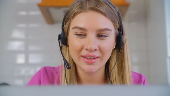 Friendly helpdesk operator woman speaking with client wearing headset with microphone in 4k video