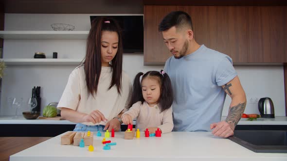 Asian Toddler Girl Playing with Sorter Puzzle Together with Parents