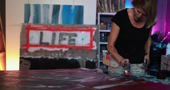 Senior woman painting inside her atelier studio at home