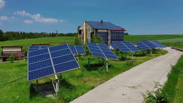 Solar panels on green field. Modern solar power plant on the roof of the house.