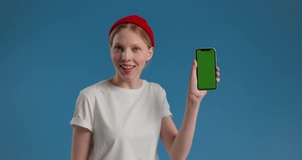 Beautiful Woman on Blue Background Showing Green Screen Camera