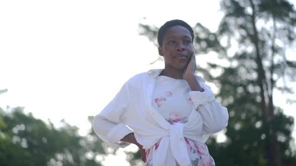 Young Confident African American Woman Standing in Sunbeam Outdoors Smiling Looking Around