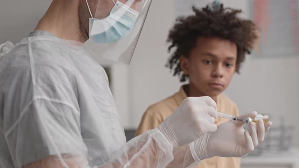 Medical Worker Filling Syringe with Medicine